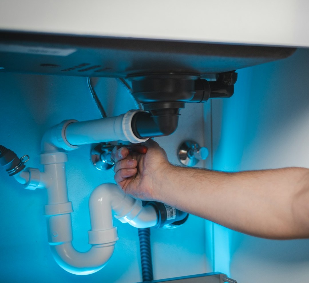 Hands performing plumbing work